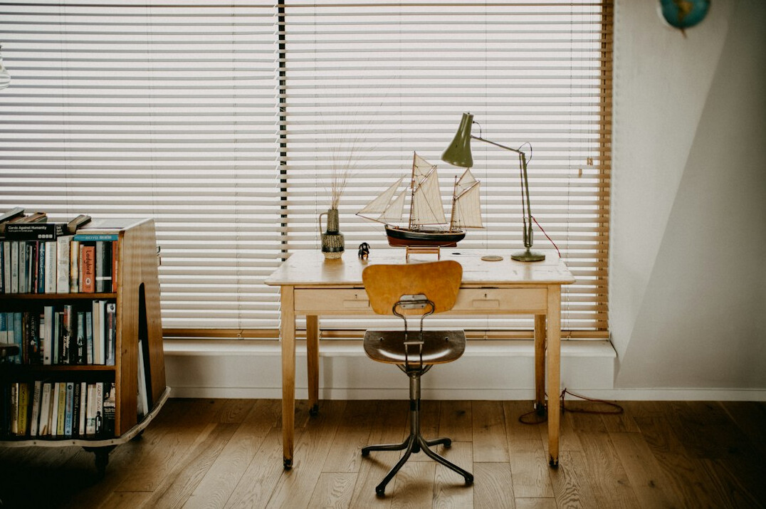 Quiet editorial office corner with archive boxes and soft daylight
